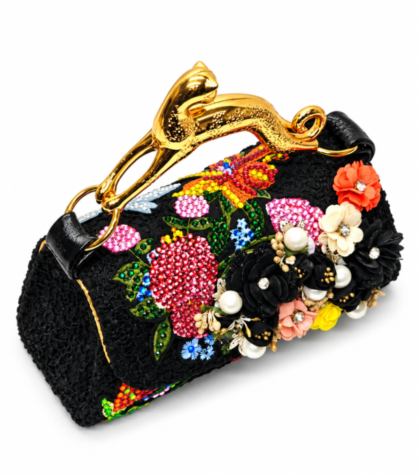 Corvane MAJESTA 8147 top handle bag, front-side angled view showing black jacquard lace, dimensional floral embellishment and sculptural gold-tone leopard handle
