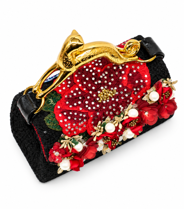 Corvane MAJESTA 6914 top angled view showing black jacquard lace, dimensional red florals, pearl accents and sculptural gold-tone leopard handle